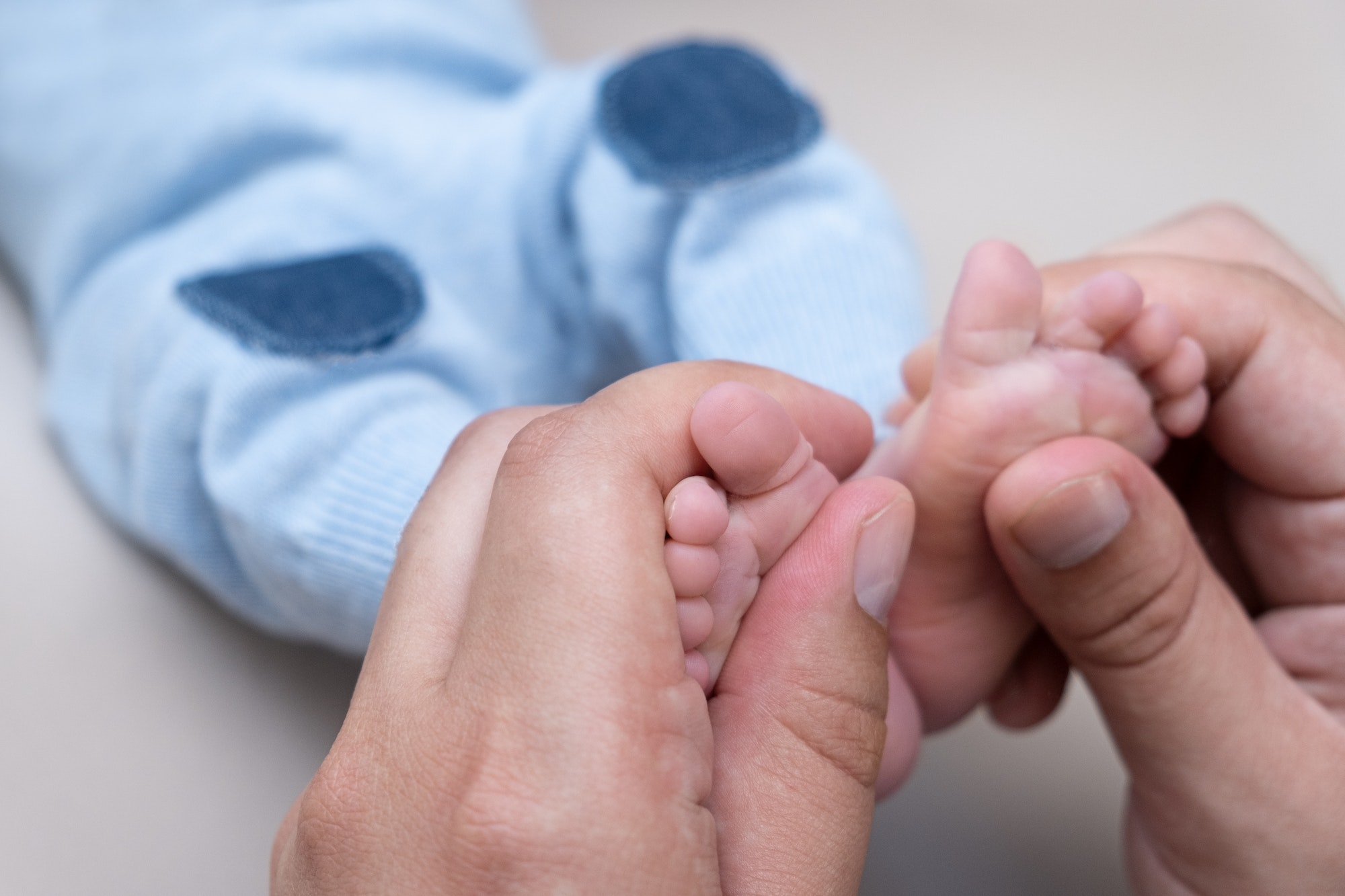 dad holds the legs of a newborn baby in his hands. paternity. father and son. daddy